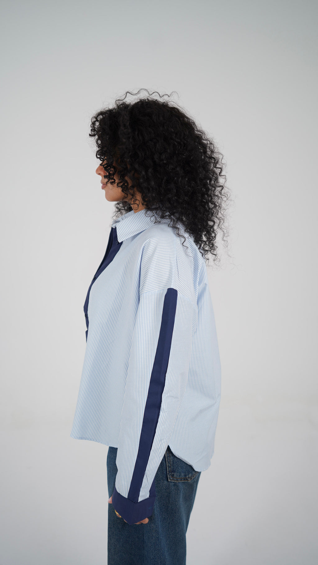 The Blue Stripe Shirt, side view with the dropped shoulder and navy sleeve panel