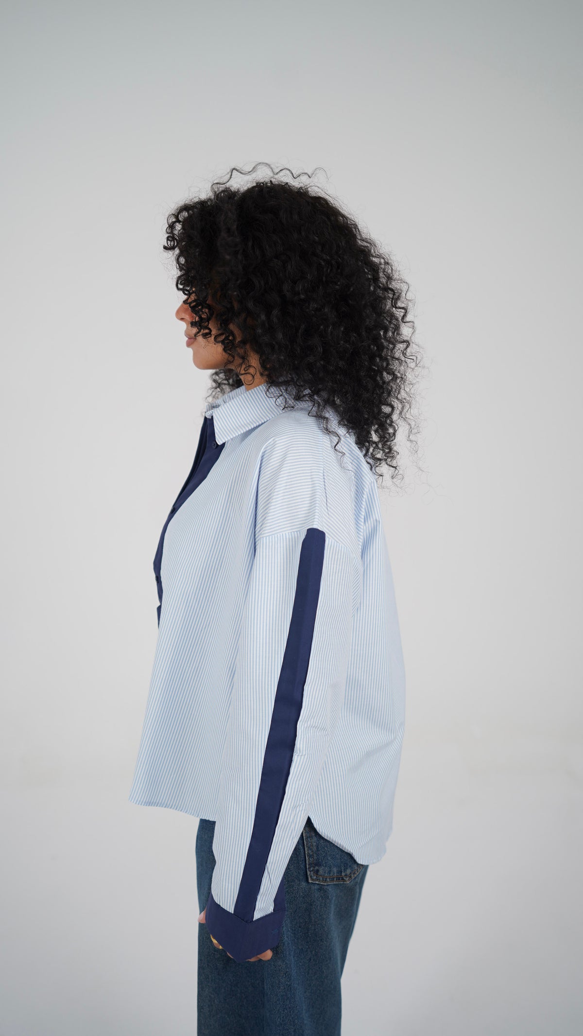 The Blue Stripe Shirt, side view with the dropped shoulder and navy sleeve panel